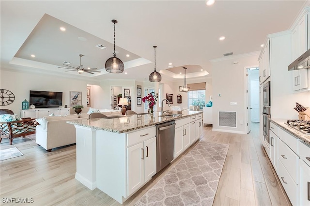 15951 Talon Ter, Punta Gorda, FL 33982 - kitchen with appliances with stainless steel finishes, a sink, light wood finished floors, open floor plan, and a tray ceiling