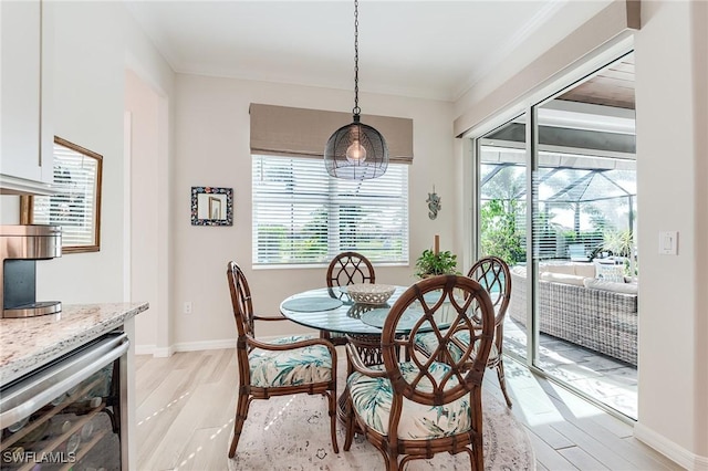 15951 Talon Ter, Punta Gorda, FL 33982 - dining room featuring crown molding, baseboards, wine cooler, and light wood-type flooring
