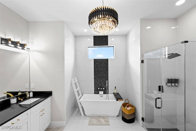 full bath with a stall shower, a freestanding tub, a chandelier, vanity, and recessed lighting