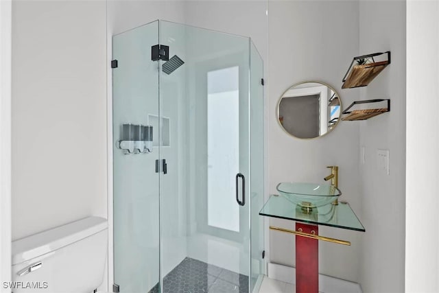 full bath with a sink, a shower stall, toilet, and tile patterned flooring