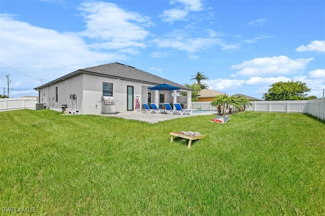 back of property with a patio area, stucco siding, and central AC