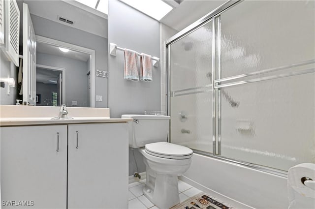 bathroom with shower / bath combination with glass door, toilet, visible vents, tile patterned flooring, and vanity