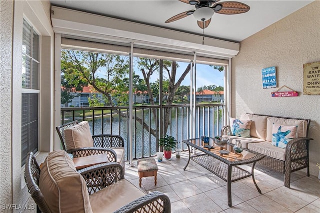 sunroom / solarium with ceiling fan, a healthy amount of sunlight, and a water view
