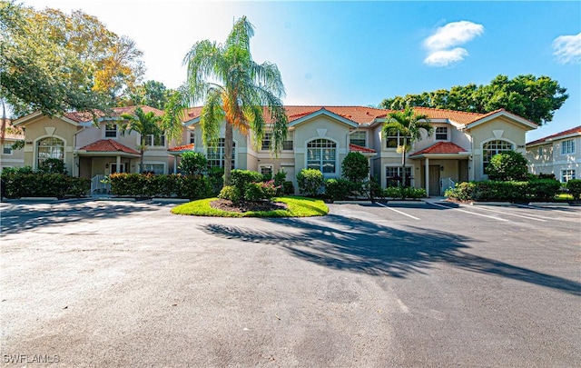 mediterranean / spanish-style house with uncovered parking and stucco siding