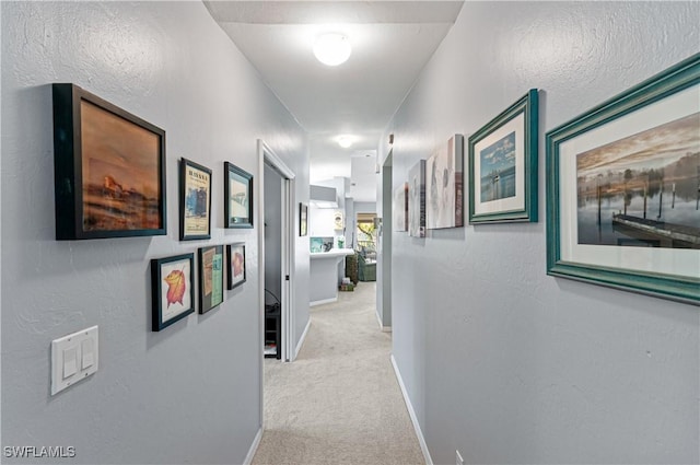 hall featuring carpet floors and baseboards