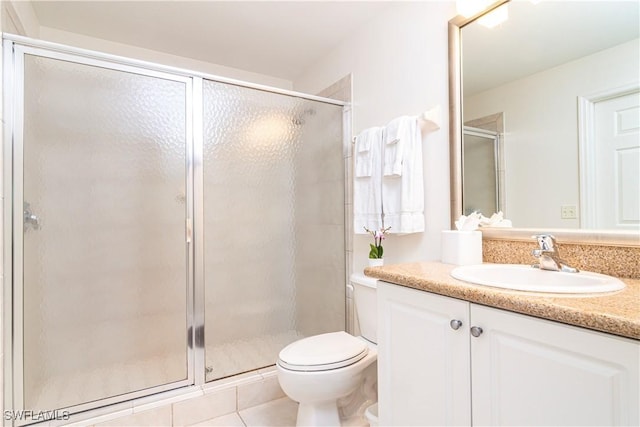 full bath with a stall shower, toilet, vanity, and tile patterned flooring