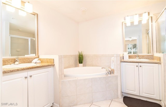 full bathroom featuring a bath, a shower stall, two vanities, and tile patterned flooring