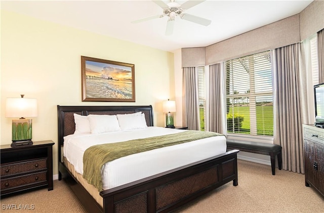 bedroom with light colored carpet, multiple windows, and baseboards