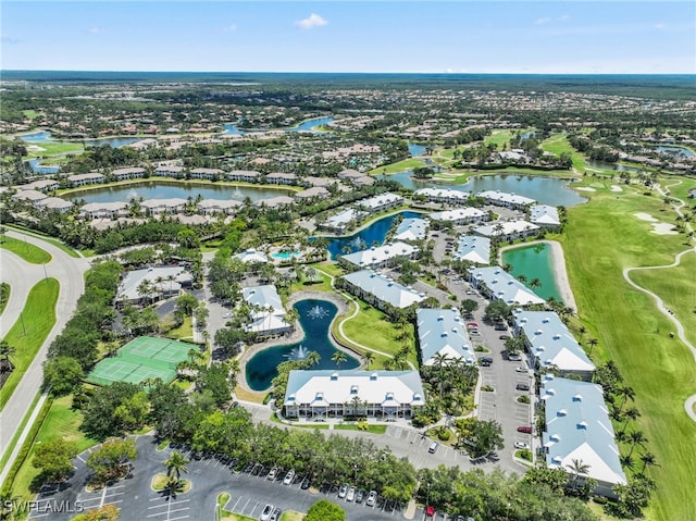 aerial view of property's location with a large body of water, a local golf course, and nearby suburban area