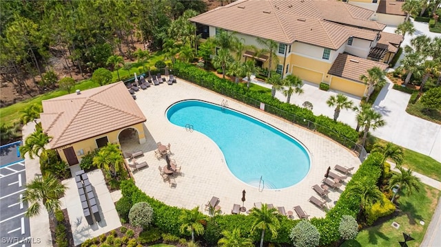 community pool featuring fence and a patio area