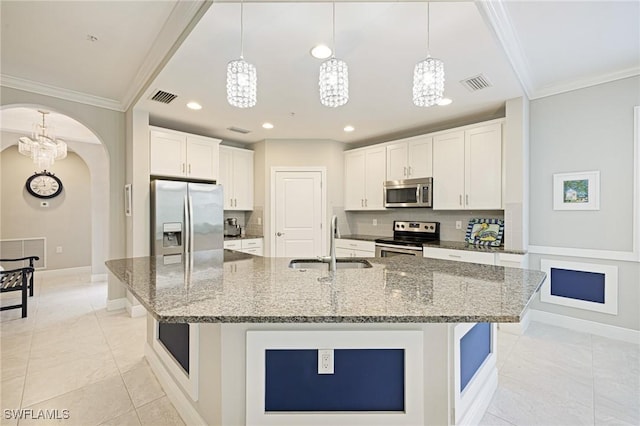 kitchen with stainless steel appliances, a sink, crown molding, arched walkways, and a chandelier