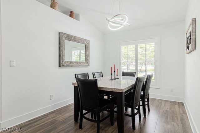 dining room with an inviting chandelier, baseboards, dark wood-style floors, and lofted ceiling