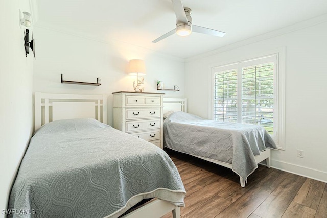 bedroom with dark wood-type flooring, a ceiling fan, baseboards, and crown molding