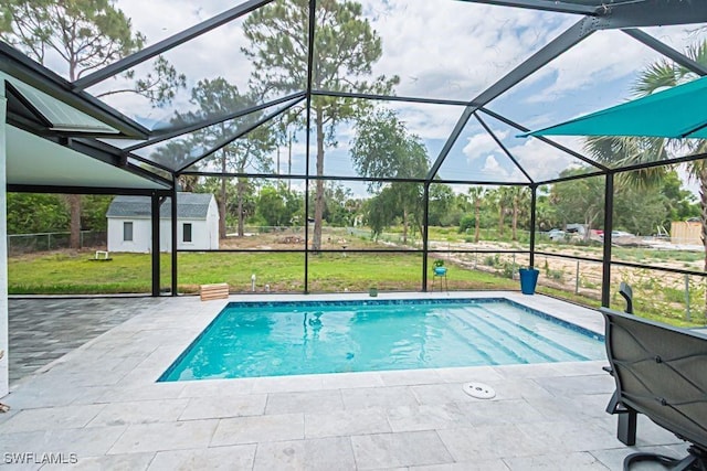 outdoor pool featuring a lawn, a patio, an outbuilding, and a lanai