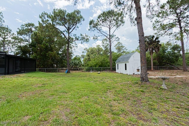 view of yard featuring an outdoor structure, a barn, and fence