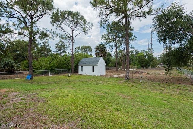view of yard featuring a fenced backyard, a storage unit, and an outdoor structure