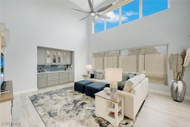 25011 Goldcrest Dr, Bonita Springs, FL 34134 - living area with light wood-type flooring, a high ceiling, a ceiling fan, and baseboards