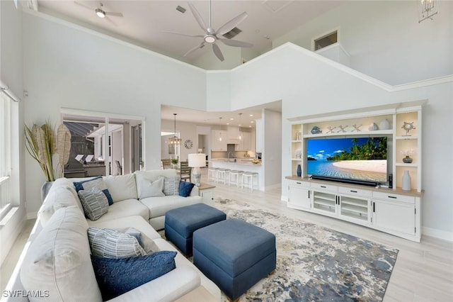 25011 Goldcrest Dr, Bonita Springs, FL 34134 - living room with light wood finished floors, baseboards, a towering ceiling, a ceiling fan, and crown molding
