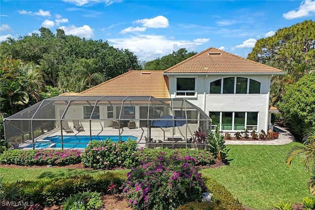 25011 Goldcrest Dr, Bonita Springs, FL 34134 - rear view of house with a tile roof, an outdoor pool, a lawn, a patio, and stucco siding