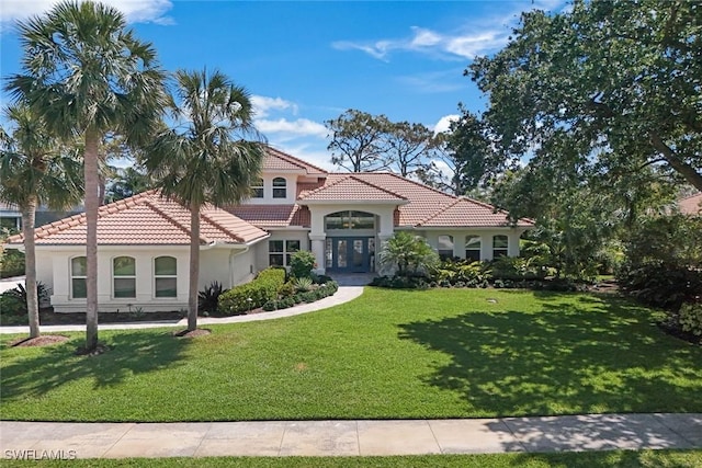 25011 Goldcrest Dr, Bonita Springs, FL 34134 - mediterranean / spanish house with a tiled roof, a front lawn, french doors, and stucco siding