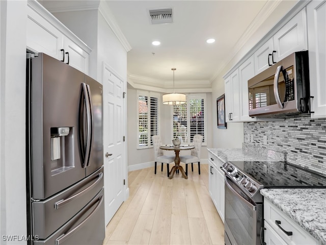 28436 Altessa Way Unit 102, Bonita Springs, FL 34135 - kitchen featuring decorative backsplash, visible vents, crown molding, appliances with stainless steel finishes, and baseboards