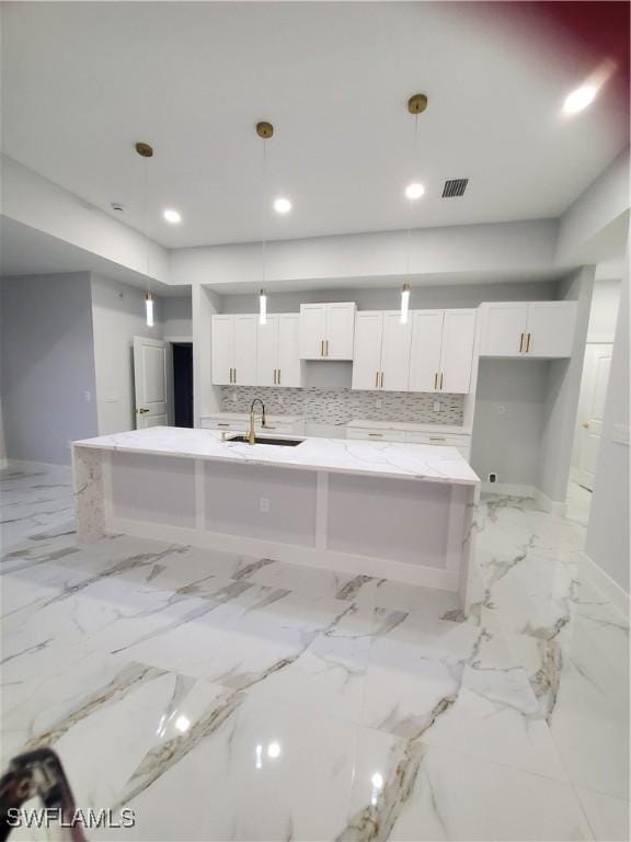 2012 Venice Ave N, Lehigh Acres, FL 33971 - kitchen featuring a sink, a large island, visible vents, baseboards, and white cabinets