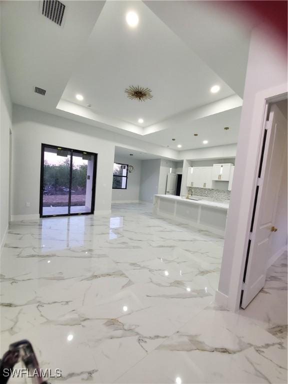 2012 Venice Ave N, Lehigh Acres, FL 33971 - unfurnished living room featuring baseboards, recessed lighting, and a tray ceiling