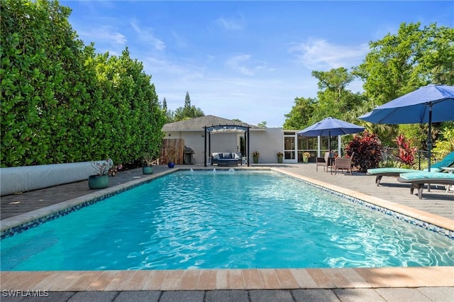 outdoor pool with fence and a patio area