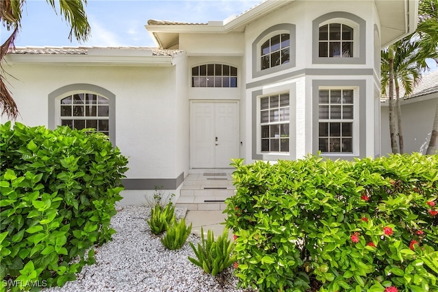42 Tahiti Rd, Marco Island, FL 34145 - doorway to property featuring stucco siding