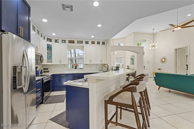 42 Tahiti Rd, Marco Island, FL 34145 - kitchen featuring stainless steel appliances, visible vents, light tile patterned floors, a kitchen bar, and blue cabinetry