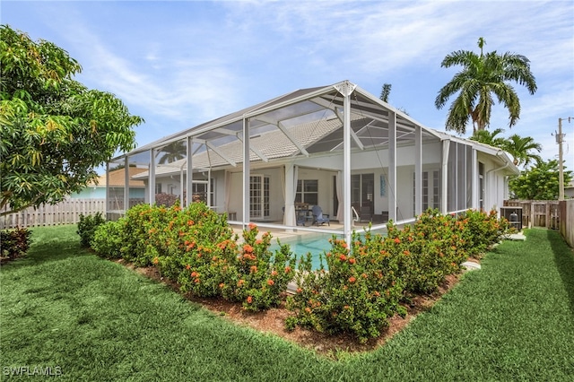 42 Tahiti Rd, Marco Island, FL 34145 - back of house featuring a fenced backyard, glass enclosure, a yard, stucco siding, and a patio area