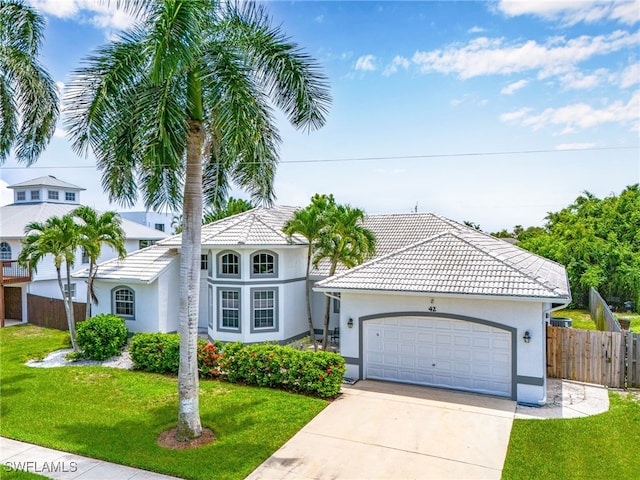 42 Tahiti Rd, Marco Island, FL 34145 - view of front of home with concrete driveway, an attached garage, fence, and a front yard