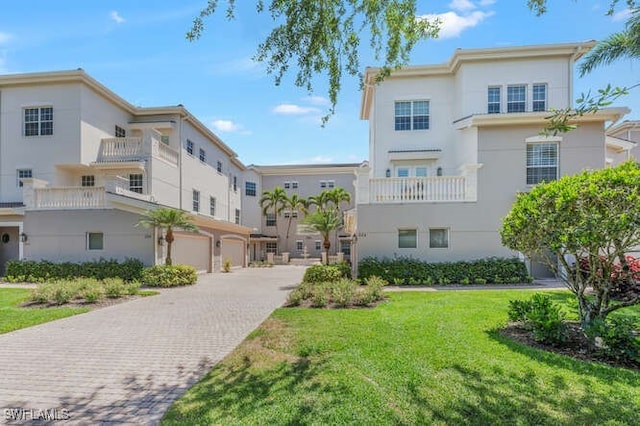 view of property's community with a yard, an attached garage, and driveway