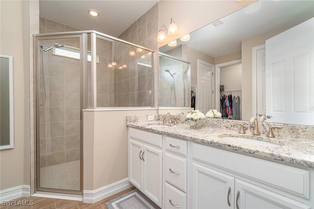 bathroom with double vanity, a sink, and a shower stall