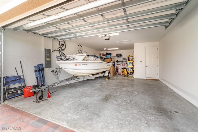 garage with a workshop area, a garage door opener, and electric panel