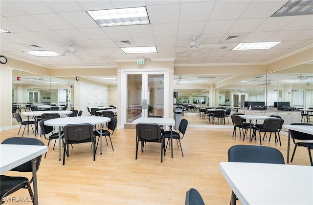 dining space with crown molding, a ceiling fan, visible vents, and light wood-style flooring