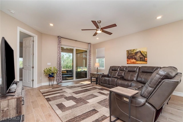 living room featuring baseboards, recessed lighting, a ceiling fan, and light wood-style floors