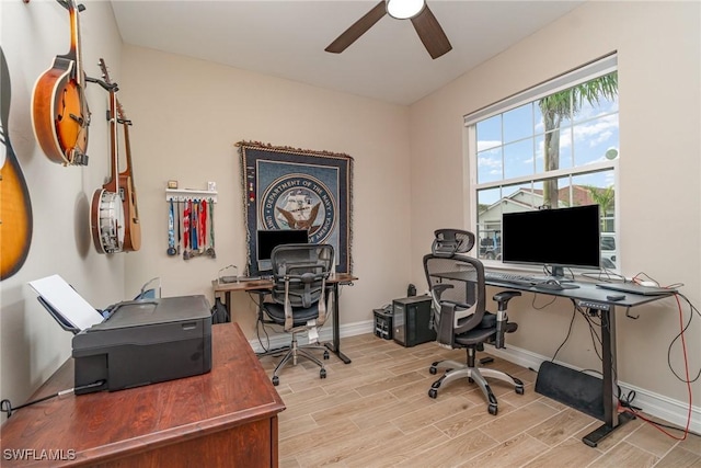 home office featuring a ceiling fan, light wood finished floors, and baseboards