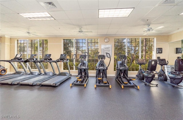 gym featuring ornamental molding, a ceiling fan, visible vents, and a paneled ceiling