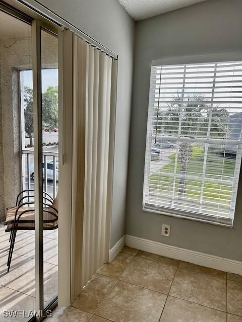 142 Santa Clara Dr Unit 7, Naples, FL 34104 - doorway with light tile patterned flooring and baseboards