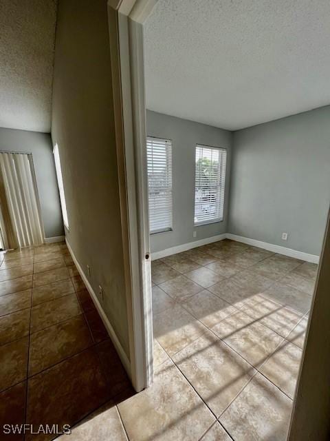 142 Santa Clara Dr Unit 7, Naples, FL 34104 - hall with baseboards, a textured ceiling, and tile patterned floors