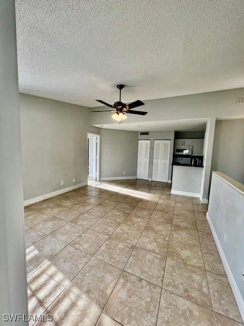 142 Santa Clara Dr Unit 7, Naples, FL 34104 - tiled spare room with baseboards, a ceiling fan, and a textured ceiling