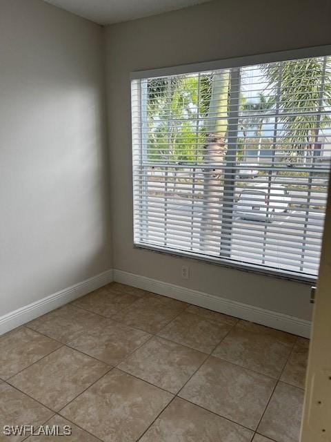 142 Santa Clara Dr Unit 7, Naples, FL 34104 - unfurnished room with light tile patterned floors, baseboards, and a wealth of natural light