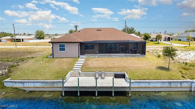 rear view of property featuring a residential view, a yard, a water view, a tiled roof, and glass enclosure
