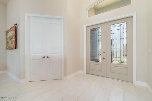 entryway with baseboards, french doors, and a healthy amount of sunlight