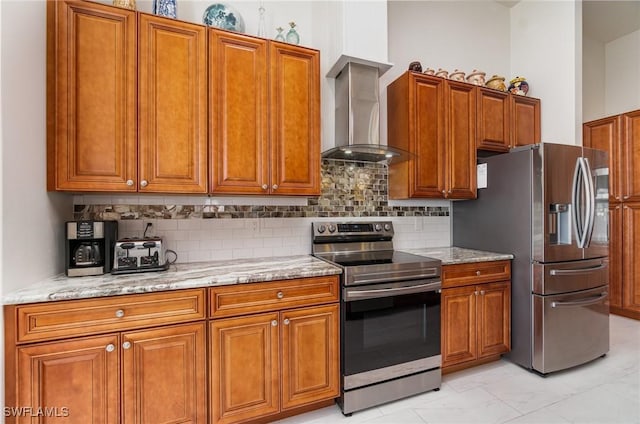 kitchen featuring wall chimney exhaust hood, brown cabinets, and stainless steel appliances