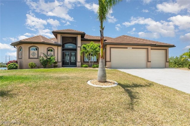 mediterranean / spanish home with stucco siding, french doors, a front yard, concrete driveway, and an attached garage