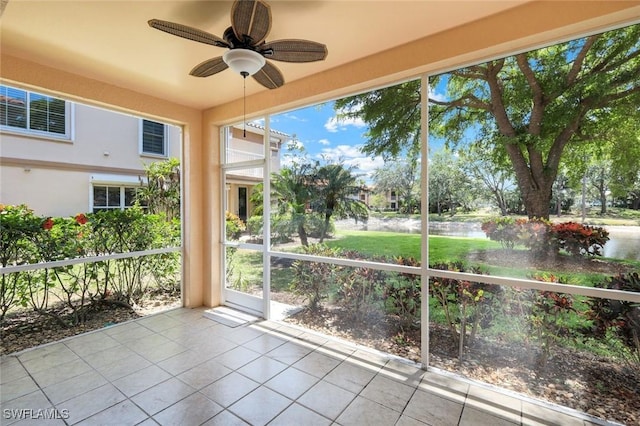 9040 Palmas Grandes Blvd Unit 101, Bonita Springs, FL 34135 - unfurnished sunroom featuring ceiling fan, tile patterned flooring, and a water view