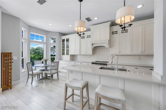 kitchen featuring visible vents, decorative backsplash, and a sink
