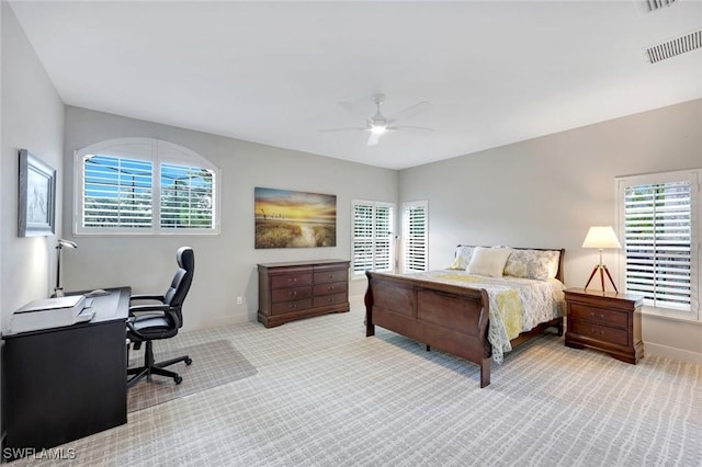 carpeted bedroom with visible vents, a ceiling fan, and multiple windows